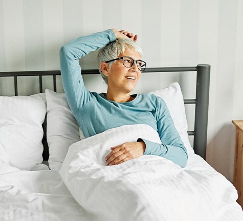 woman lying in bed recovering from implant placement