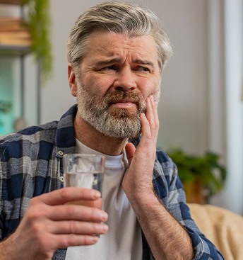 man holding his face with minor discomfort in his mouth