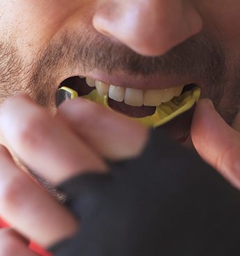 closeup of a guy putting in a mouthguard