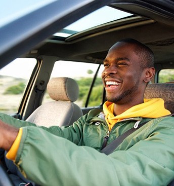 Man smiles while driving