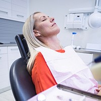 Relaxed woman with eyes closed in dental chair