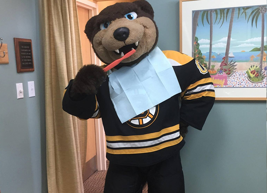 Mascot bear demonstrating tooth brushing