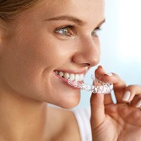 Woman placing Invisalign tray