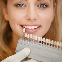 Woman's smile compared with tooth color chart