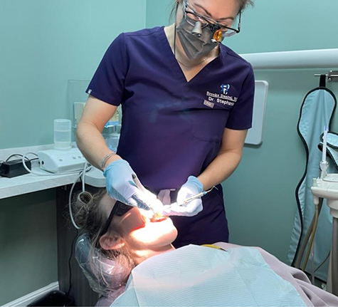 Dental team member examining a patient's teeth