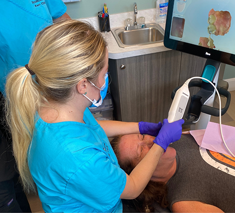Dental team member taking digital scans of a patient's teeth