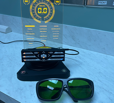 Dental laser pen on a countertop next to a pair of sunglasses