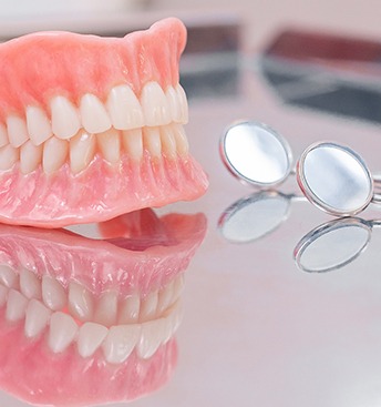 full dentures next to dental mirrors