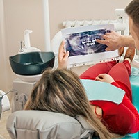 Dentist and patient looking at digital x-rays