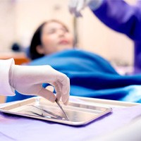 A blurred view of dentists and a woman in a dental clinic