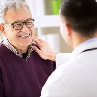 Patient smiling at his Winthrop implant dentist  