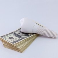 Model implant and money representing the cost of dental implants in Winthrop 