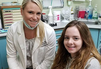 young girl and dentist smiling in dental office