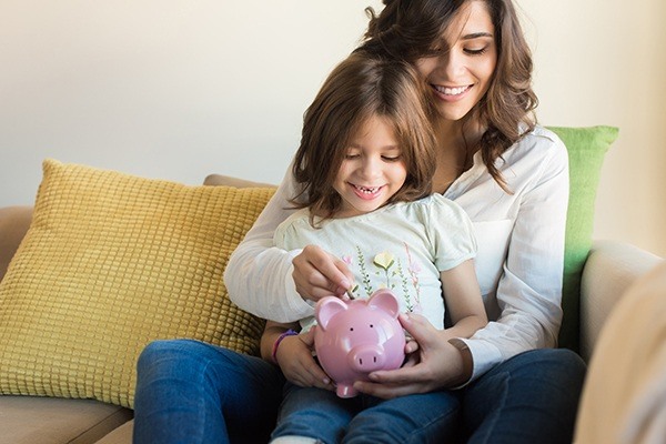 mom with daughter holding a piggy bank