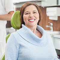 Older woman in dental exam room smiling
