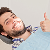 Man in dental chair giving thumbs up