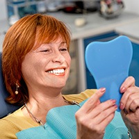 Senior woman looking at smile in mirror