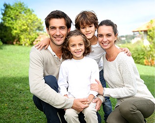 Smiling mother father and two children outdoors