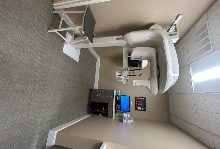 C T cone beam scanning machine standing against a wall