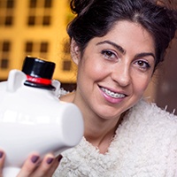 woman with braces holding a piggy bank 