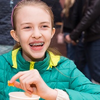 smiling girl with braces eating 