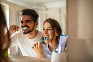A couple brushing their teeth together.