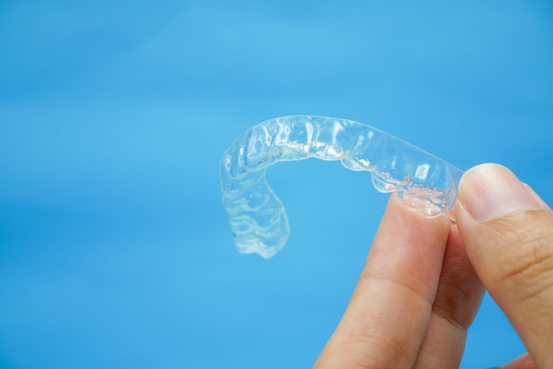 Closeup of patient holding Invisalign tray