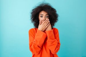 woman covering her mouth with cavities during Invisalign