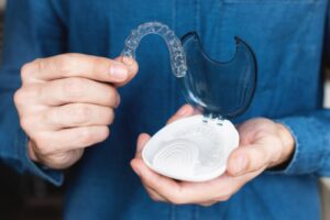 Man holding his Invisalign tray